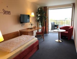 バート・シェーンボルンにあるHotel Häfnerのベッド、テーブル、椅子が備わるホテルルームです。