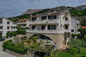 an apartment building with a mountain in the background at Apartments Andrea I in Baška