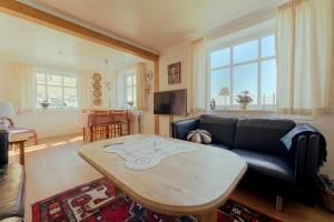 a living room with a couch and a table at Lovely 4-BR house / Sea view / Nature in Oyndarfjørður