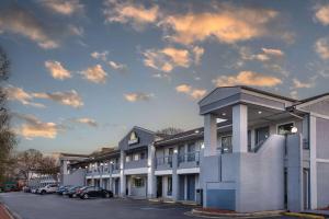 a building with cars parked in a parking lot at Days Inn by Wyndham Raleigh Glenwood-Crabtree in Raleigh