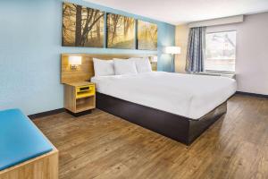 um quarto de hotel com uma cama e uma janela em Days Inn by Wyndham Raleigh Glenwood-Crabtree em Raleigh