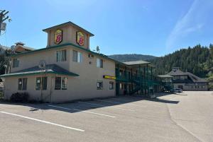 a large building with a clock tower in a parking lot at Super 8 by Wyndham Sicamous in Sicamous