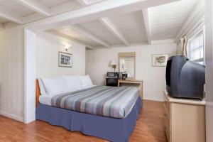 a bedroom with a bed and a flat screen tv at Travelodge by Wyndham Fairfield/Napa Valley in Fairfield