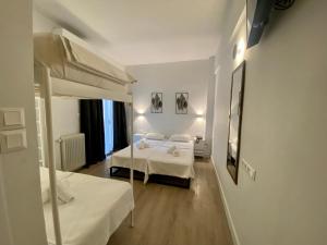 Habitación de hotel con 2 camas y espejo en Platon Hotel en Piraeus