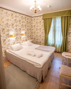 a bedroom with a large bed in a room at Ombergs Turisthotell in Ödeshög