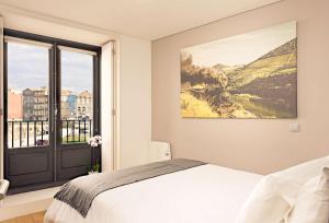 1 dormitorio con cama y ventana grande en oldcity design apartments, en Oporto
