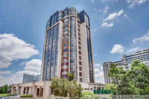 a tall white building with many windows at Sandton Skye Serviced Apartments in Johannesburg