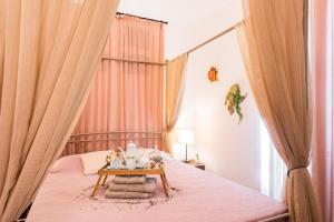 a bedroom with a bed with curtains and a table at Alegria rooms in Athens