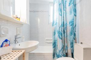 a bathroom with a sink toilet and a shower curtain at Alegria rooms in Athens