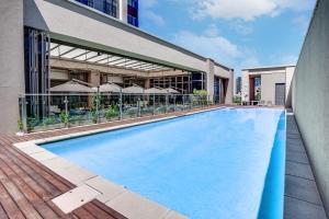 a swimming pool in front of a building at Sandton Skye Serviced Apartments in Johannesburg