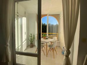 a room with a table and chairs and a balcony at Tesoro del Eden in Torrevieja