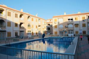 a swimming pool in the middle of two buildings at Tesoro del Eden in Torrevieja