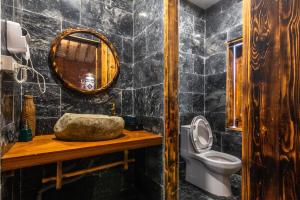 een badkamer met een toilet en een spiegel bij Sapa Riverside Homestay in Sa Pa
