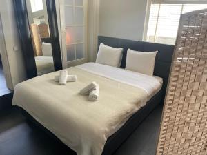 - un lit avec 2 serviettes et un miroir dans l'établissement Hotel Doppenberg, à Zandvoort