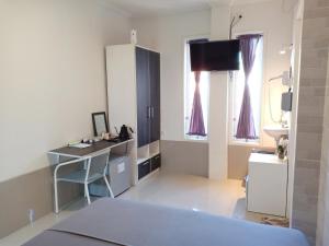 a room with a bed and a desk and a sink at Simple Kuta Bedroom in Denpasar