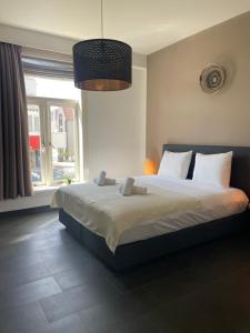 - une chambre avec un grand lit et une grande fenêtre dans l'établissement Hotel Doppenberg, à Zandvoort