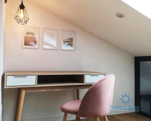 a desk in a room with a pink chair at Cabanela Maitia Apto Telmo Duplex in Ribadeo