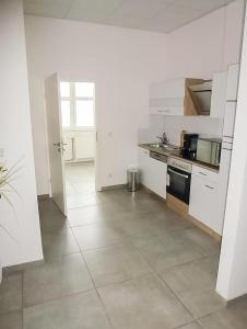 een keuken met witte apparatuur en een tegelvloer bij PREMIUM - 24 Betten - 9 Appartements zentral in Oer-Erkenschwick - homes of ruhr in Oer-Erkenschwick