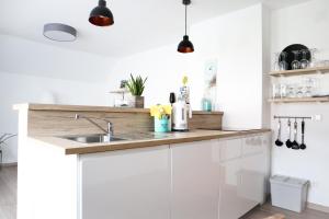 a kitchen with white cabinets and a sink at Appartements Setzbergblick in Spitz