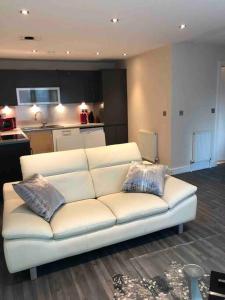 a white couch in a living room with a kitchen at Bond Street Luxury Apartment Central Chelmsford in Chelmsford