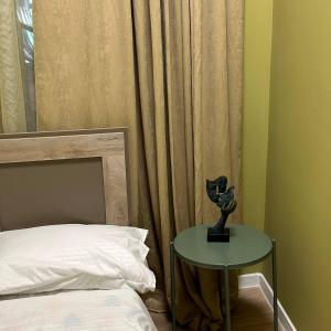 a bedroom with a bed and a table with a lamp at La Casa EmilioAngi in Yerevan