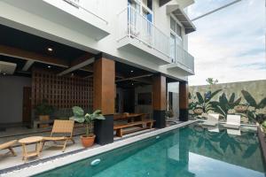 een villa met een zwembad en een huis bij Sarang Comfort in Canggu