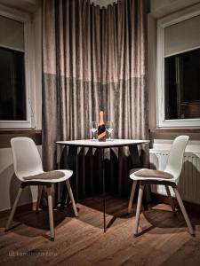a table with two chairs and a table with wine glasses at Apartament VIP PROMENADA in Mrągowo