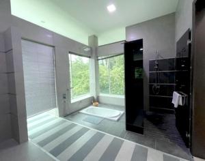 a large bathroom with a tub and a large window at Teluk Cempedak Seventh Haven in Kuantan