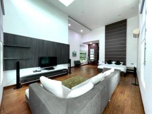 a large living room with a couch and a tv at Teluk Cempedak Seventh Haven in Kuantan