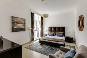 a bedroom with a bed and a couch at VayK - Modern Four Bedroom with Sea View in Dubai Marina in Dubai