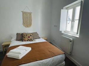 a bedroom with a bed with two towels on it at Casa da Oliveira in Évora