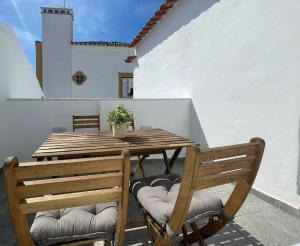 a wooden table and chairs on a patio at Casa da Oliveira in Évora