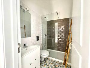 a white bathroom with a toilet and a sink at Casa da Oliveira in Évora +15 photos