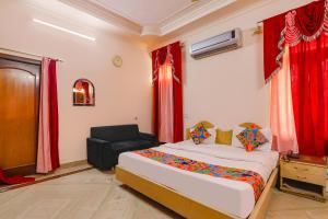 une chambre avec un lit et une chaise dedans dans l'établissement FabHotel Raka Inn, à Allahābād