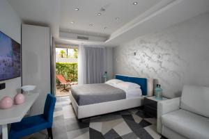 - une chambre avec un lit, une chaise et un canapé dans l'établissement Elegance Riccione, à Riccione