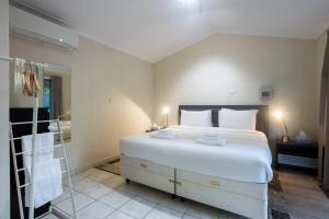 1 dormitorio con 1 cama blanca grande y baño en Studio Granny Flat in Melville with Patio en Perth