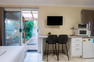 una cocina con 2 sillas en una barra con microondas en Studio Granny Flat in Melville with Patio en Perth