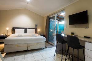 1 dormitorio con 1 cama y escritorio con sillas en Studio Granny Flat in Melville with Patio en Perth