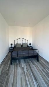 a bedroom with a bed and a wooden floor at LAS MESAS HOUSE Ocean Escape in San Miguel de Abona