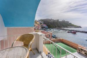 a balcony with chairs and a view of the water at Corricella Moonlight - Gioia Apartments in Procida