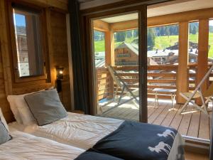 a bedroom with a bed and a view of a deck at Le Lodge Chasse Montagne in Les Gets