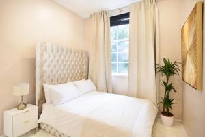 a bedroom with a white bed and a window at Beautifully Decorated & Central 2bed Apartment (C) in Brighton & Hove