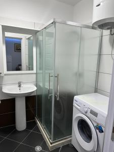 a bathroom with a shower and a sink and a washing machine at Dream Apartments Shengjin in Shëngjin +24 photos