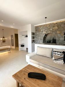 a living room with a couch and a fireplace at Quattro Venti Suites Mykonos in Tourlos