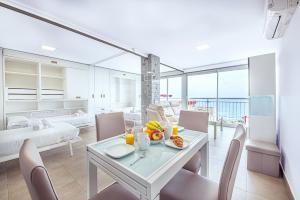 une salle à manger blanche avec une table et des chaises dans l'établissement Myflats Premium Costa Blanca, à Alicante