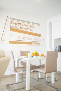 Una mesa de cocina con sillas y un cartel en la pared. en Stay In Costa Blanca, en Alicante