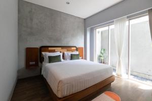 een slaapkamer met een bed en een groot raam bij Sarang Comfort in Canggu +127 foto's