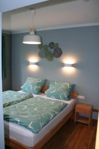 1 Schlafzimmer mit 2 Betten mit blauen Wänden und Leuchten in der Unterkunft Haus Brunnenkunst in Arnstadt