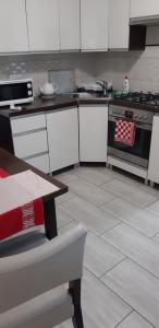 cocina con armarios blancos y fogones en Apartament u Janiny, en Jeżów Sudecki