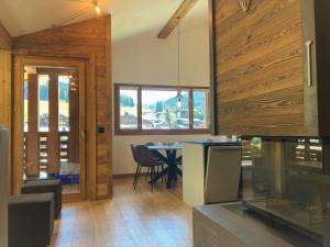 a kitchen with wooden walls and a table with chairs at Le Lodge Chasse Montagne in Les Gets
